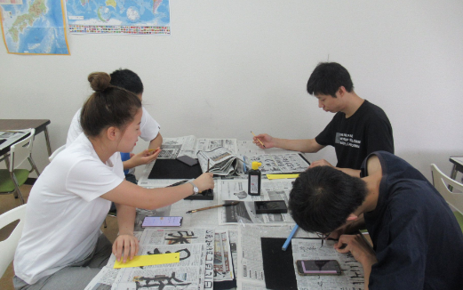 Students are writing wishes for Tanabata Festival in calligraphy.